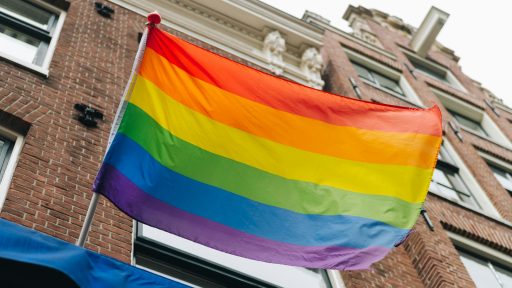 a rainbow flag is flying in front of a building