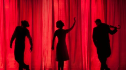 silhouette of three performers on stage