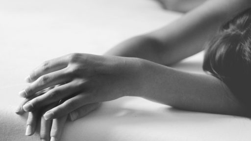 grayscale photo of person lying on bed