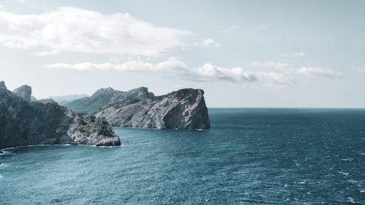 body of water under white clouds