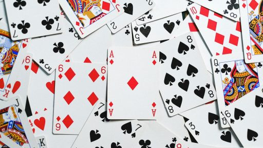 A collection of scattered playing cards showcasing various suits and numbers for casino themes.