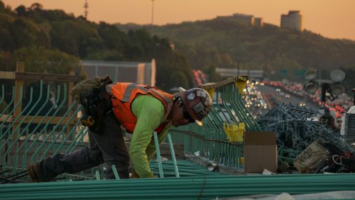man on green galvanized iron sheet holding green bar