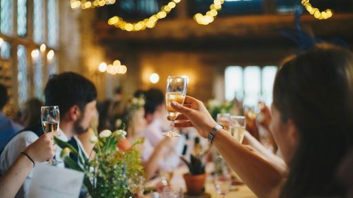 people raising wine glass in selective focus photography