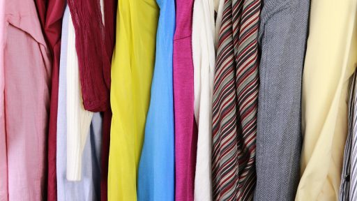 Man die kleding sorteert en zijn kast inruimt voor een capsulegarderobe