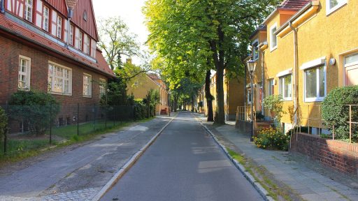 Een drukke straat in Berlijn op een zomerse dag met mensen op een terras