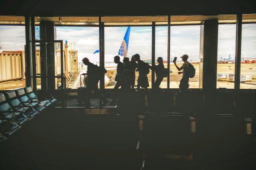 Groep vrienden die samen een zomerse groepsreis plannen op het vliegveld