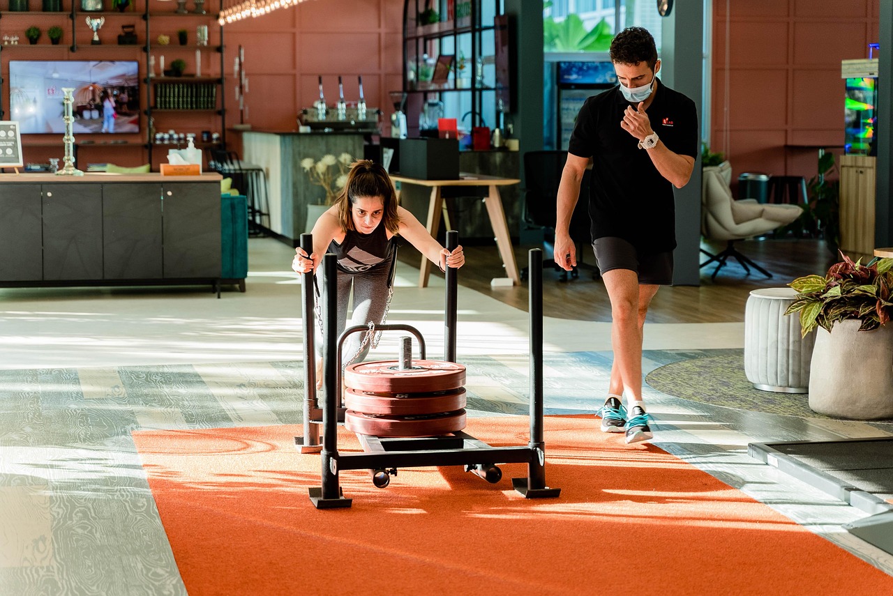 Man die een zware sled duwt in een sporthal tijdens een Hyrox-training