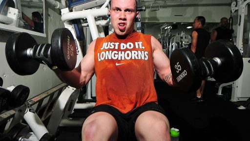 Man van boven de 40 die gewichten heft in een gym
