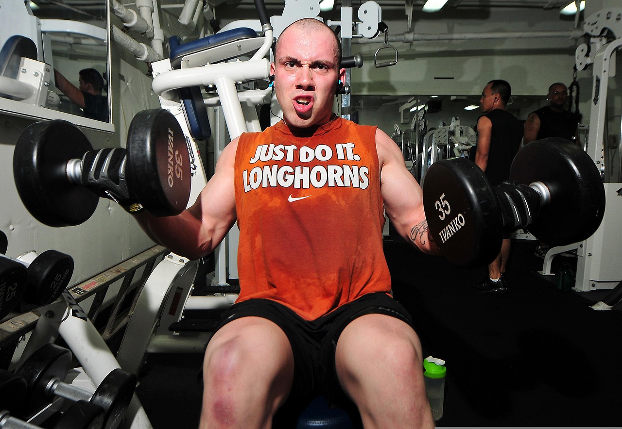 Man van boven de 40 die gewichten heft in een gym