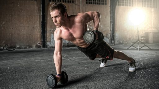 Krachttraining schoenen op de vloer van een sportschool naast een squat rack