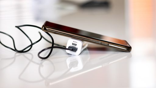 Accu van elektrisch gereedschap op een lader naast een accuboor