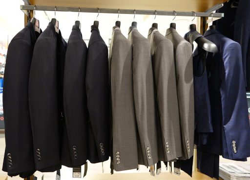 Interieur van een herenkledingwinkel met nette jassen en overhemden op rekken
