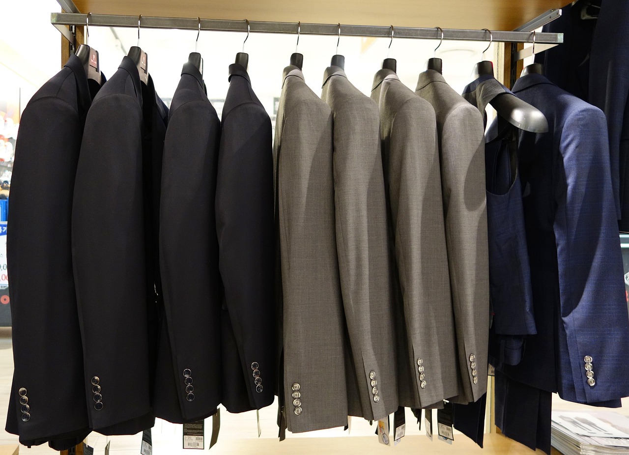 Interieur van een herenkledingwinkel met nette jassen en overhemden op rekken