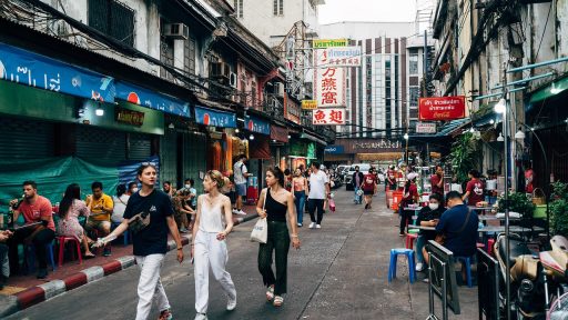 Drukke straatmarkt in Bangkok met toeristen en lokale verkopers