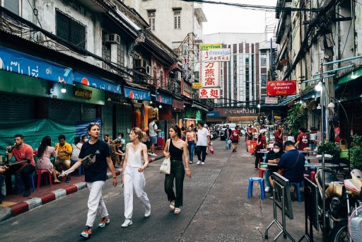 Drukke straatmarkt in Bangkok met toeristen en lokale verkopers