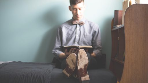 Een man leest een boek over financiën en vermogen opbouwen