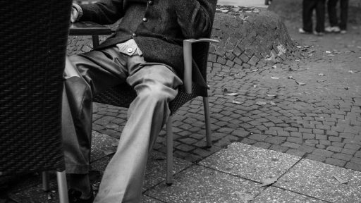 Man in een jas lopend op een regenachtige straat in de herfst