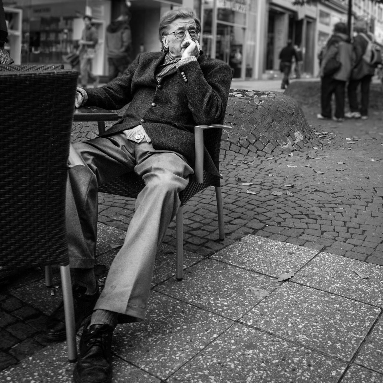 Man in een jas lopend op een regenachtige straat in de herfst