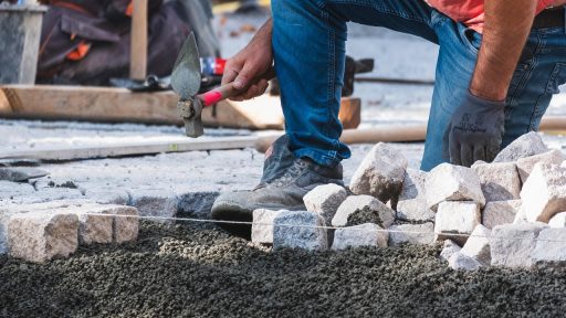 Stratenmakers gereedschap inclusief trilplaat en hamer op een bouwlocatie