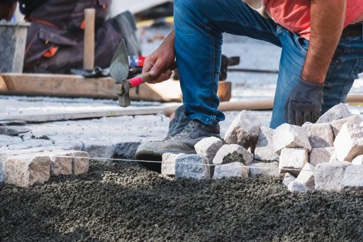 Stratenmakers gereedschap inclusief trilplaat en hamer op een bouwlocatie